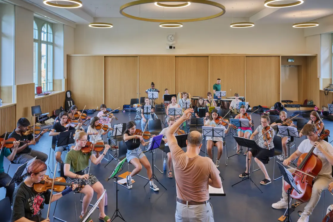 Ruwen Kronenberg dirigiert eine stattliche Anzahl an Jugendlichen, die für das Programm Go East mit Auftritten am 9. und 10. September in Grenchen und Solothurn proben. Bild: José R. Martinez